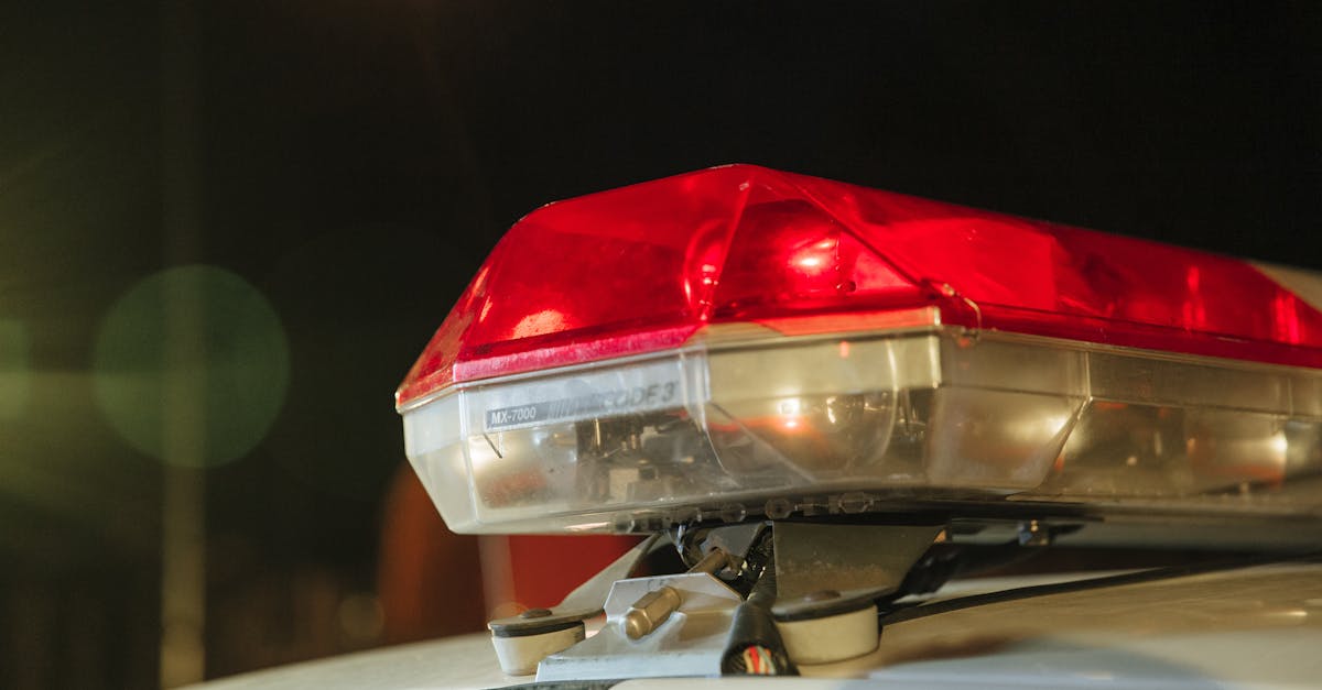 Detailed view of a police car's red siren light shining at night.