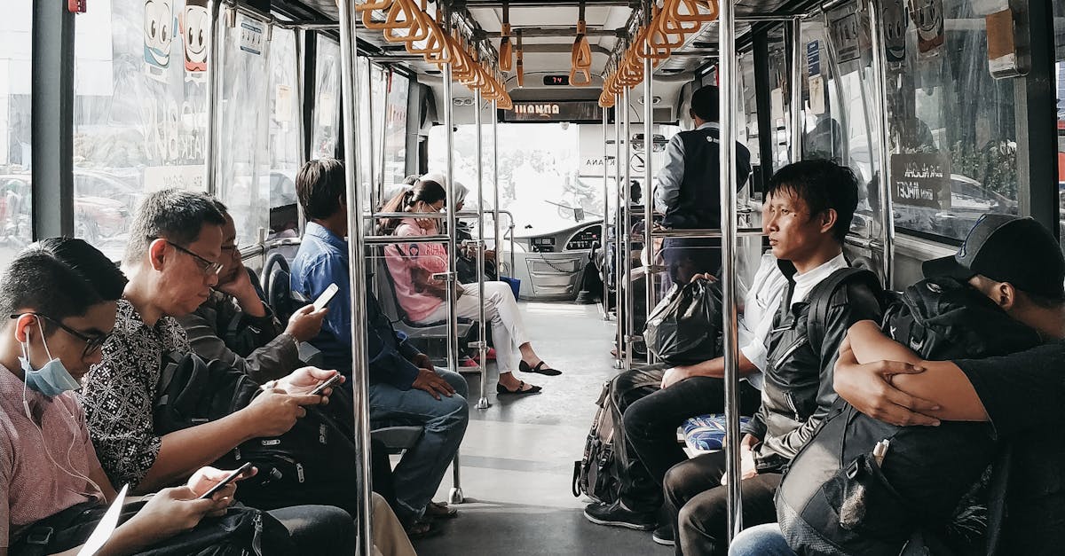 Passengers occupy seats inside a city bus as it moves through an urban area, showcasing daily commute life.